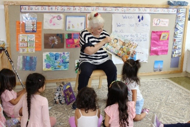 Senior reads to a group of children